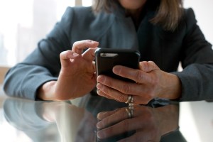 PwC_Rep_USA_NYC_JFB_042316_030.jpg Woman sitting at a table near a window checking her phone, cell, mobile Rings